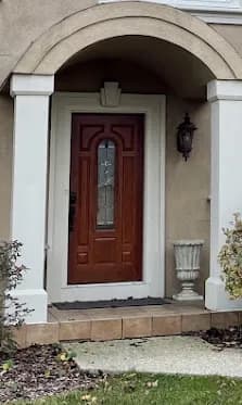 Arched mahogany craftsman entry with sidelights
