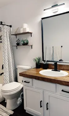 A representative bathroom: white shaker vanity, quartz top, brushed pulls.