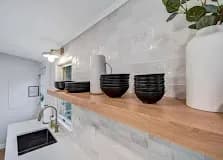 Open shelving: Floating wood shelves in place of upper cabinets. Lightens a wall and shows off the stuff you actually use.