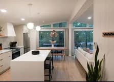 White slab kitchen with built-in banquette under the window.