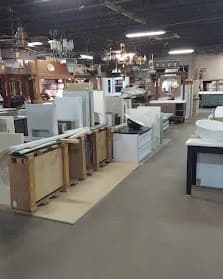 Multiple vanities lined up, lighting fixtures hanging, white walls. The depth of what we keep on hand.