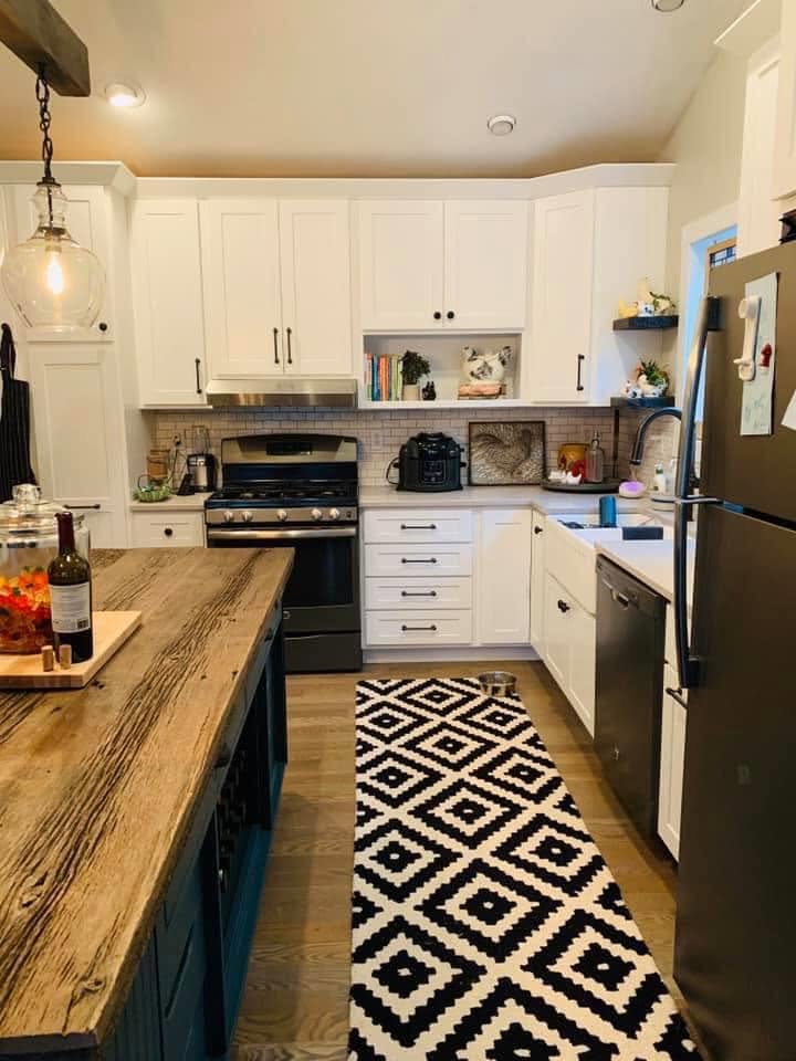 White kitchen with wood island.