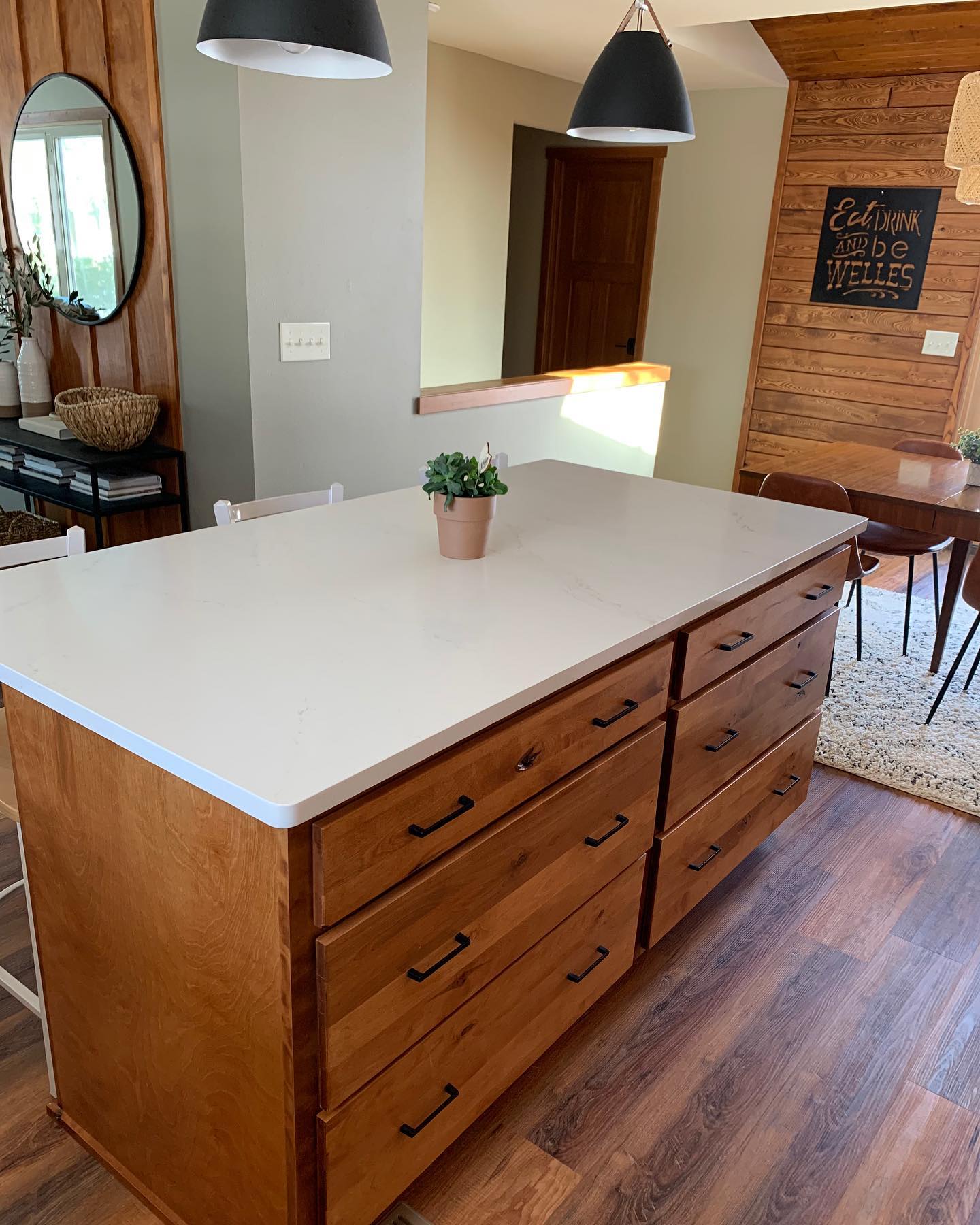 Wood island kitchen with black pendant lights.